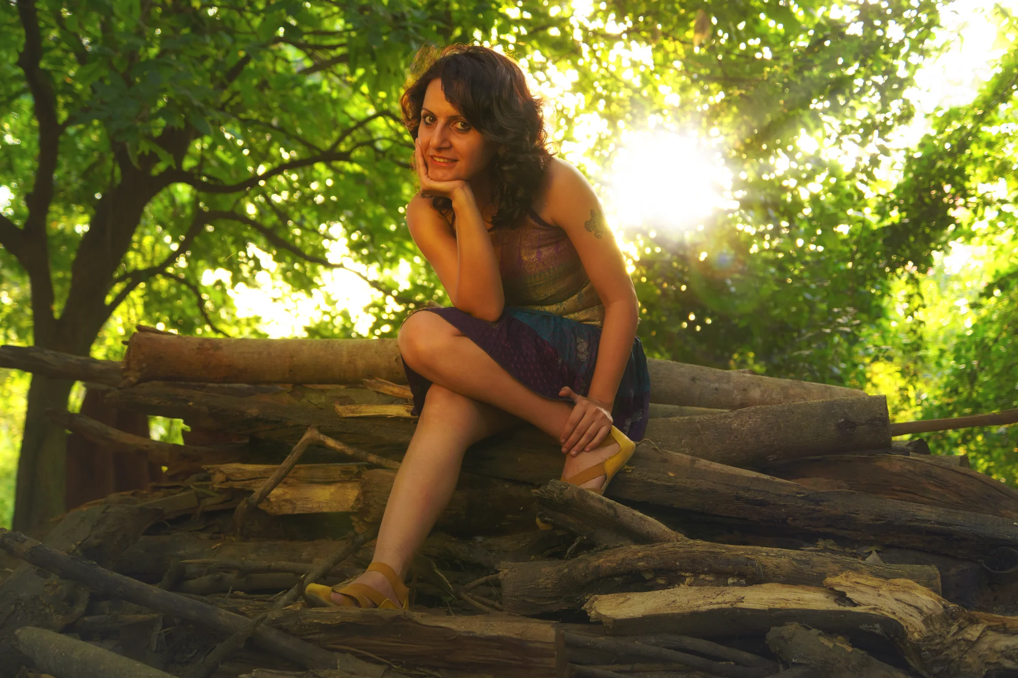 Shruti Dhawan seated outdoors in a sunlit woodland